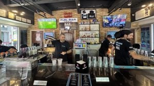 Bartenders behind a bar making drinks